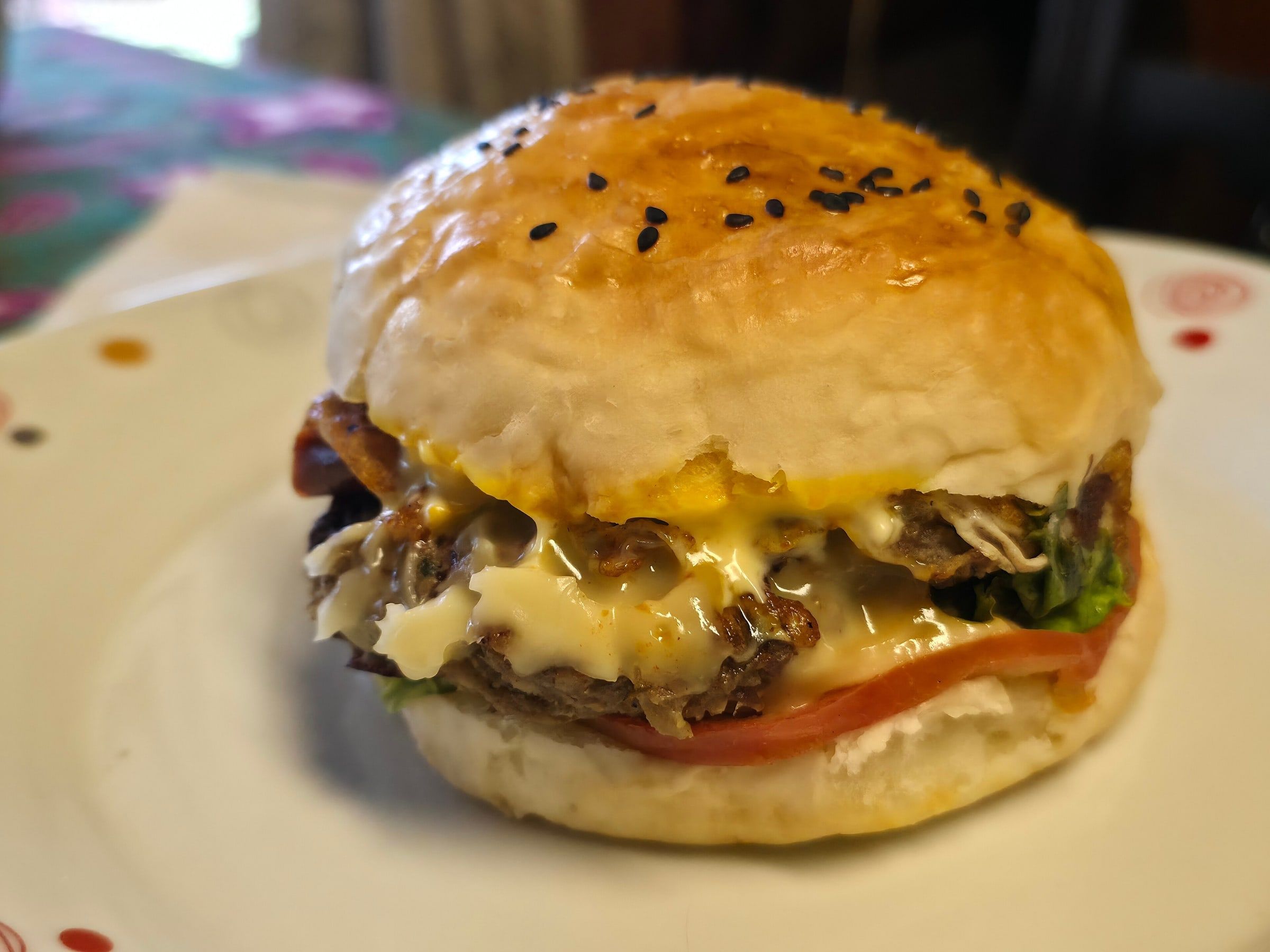 Hamburguesa doble con queso fundido chorreando sobre la carne, en pan brillante