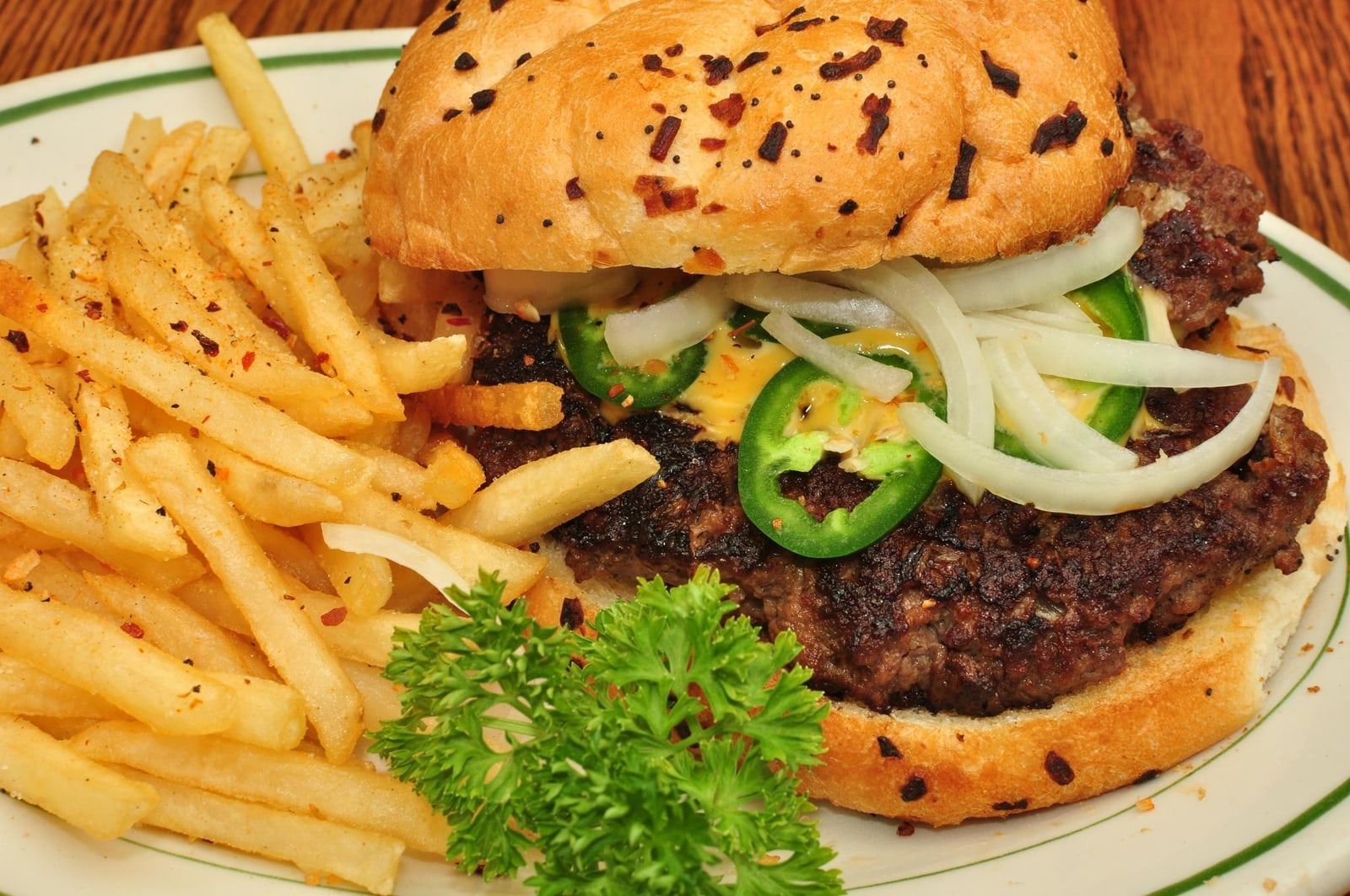 Hamburguesa con jalapeños y cebolla, acompañada de papas fritas